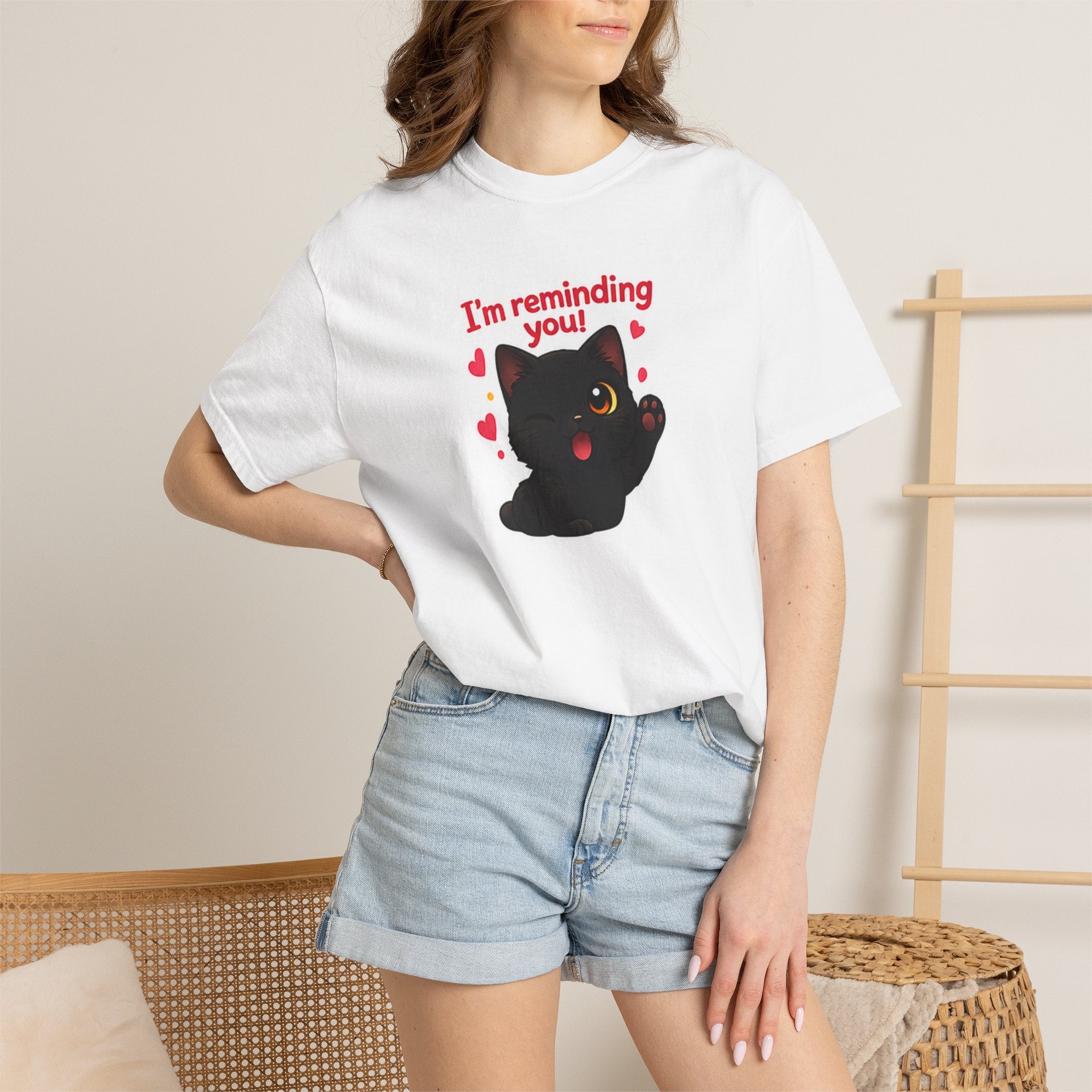 Black T-shirt featuring a cute kitten with the text "I’m Reminding You" by Printify, displayed on a model.